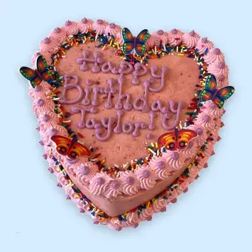 Pink cake decorated with butterflies, rainbow sprinkles, and a birthday message