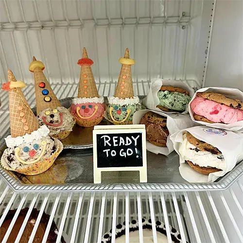 Clown cones and ice cream sandwiches in a cooler with a sign reading, 'Ready to go!'